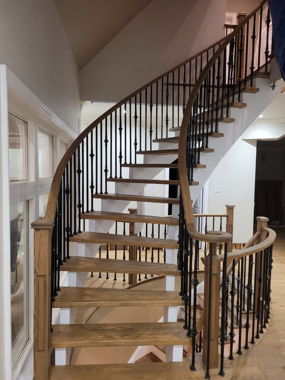 Curved hardwood staircase with iron railing, Greater Toronto Area